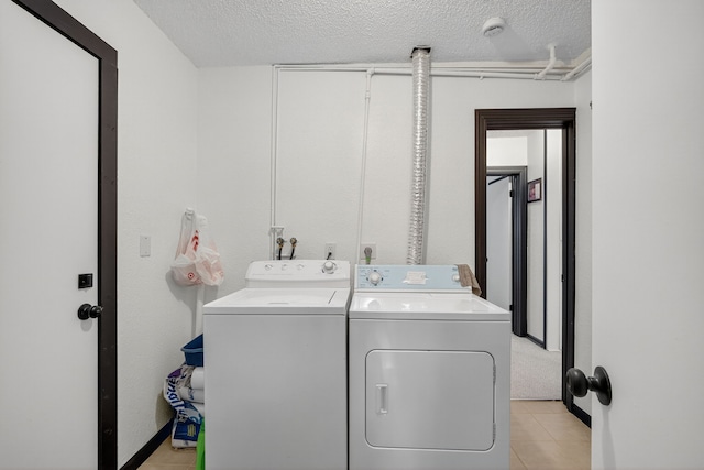 3605 53rd St, Des Moines, IA 50310 - washroom featuring washer and clothes dryer, a textured ceiling, and light tile patterned floors