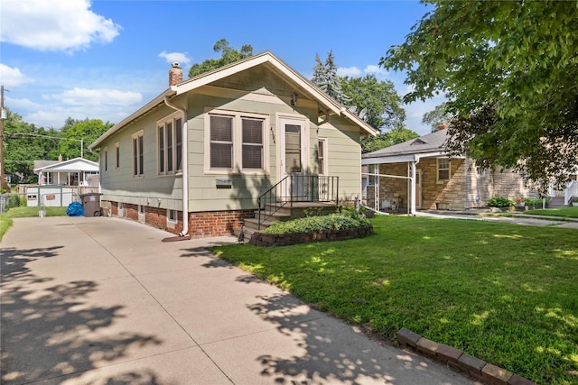 4104 1st St, Des Moines, IA 50313 - view of front of home with a chimney, a front lawn, and concrete driveway