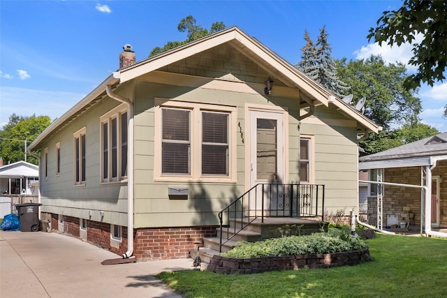 4104 1st St, Des Moines, IA 50313 - view of front facade featuring a chimney, a front yard, and a patio