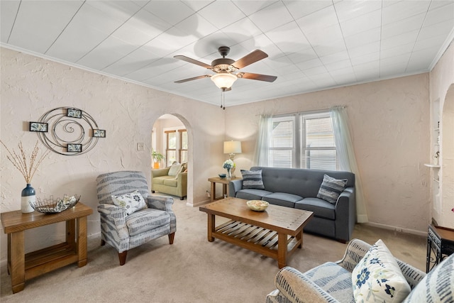 4104 1st St, Des Moines, IA 50313 - living area featuring arched walkways, a textured wall, ornamental molding, a ceiling fan, and carpet floors