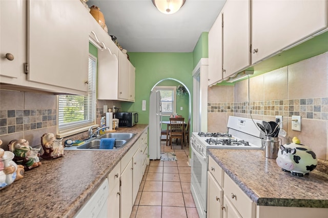 4104 1st St, Des Moines, IA 50313 - kitchen featuring white appliances, plenty of natural light, light tile patterned floors, and tasteful backsplash