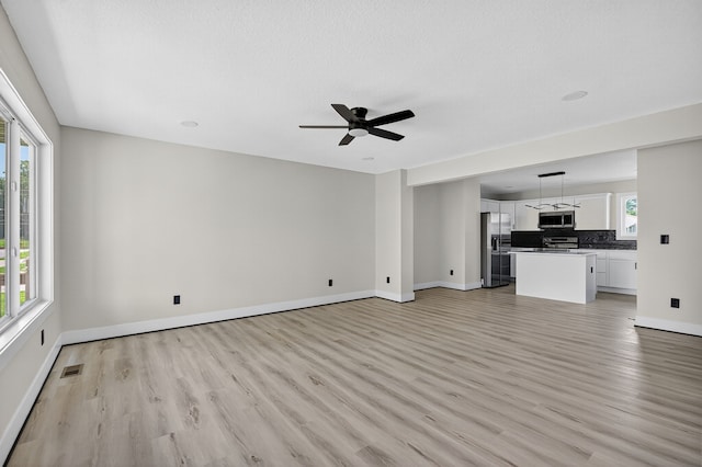 1218 Mccormick St, Des Moines, IA 50316 - unfurnished living room featuring light wood finished floors and a ceiling fan