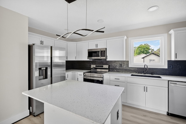 1218 Mccormick St, Des Moines, IA 50316 - kitchen with stainless steel appliances, backsplash, light wood-style floors, white cabinetry, and recessed lighting