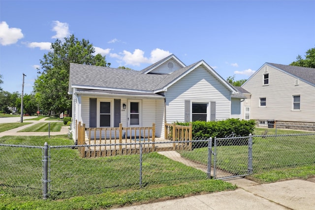 204 N Gaines St, Stuart, IA 50250 - bungalow with covered porch, a gate, a fenced front yard, and a shingled roof