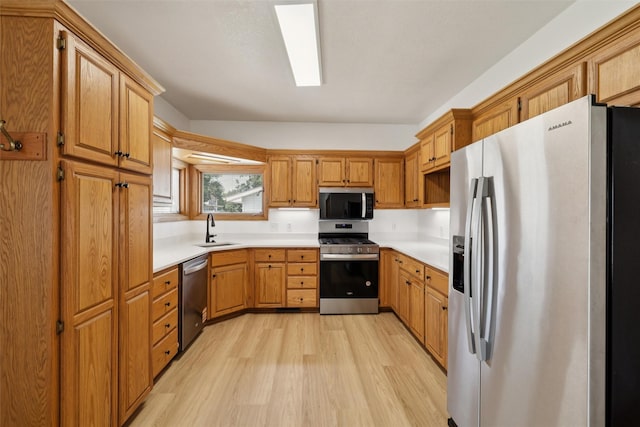204 N Gaines St, Stuart, IA 50250 - kitchen with appliances with stainless steel finishes, light wood-type flooring, light countertops, and brown cabinets