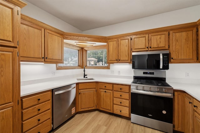 204 N Gaines St, Stuart, IA 50250 - kitchen with appliances with stainless steel finishes, light wood-type flooring, brown cabinets, and light countertops