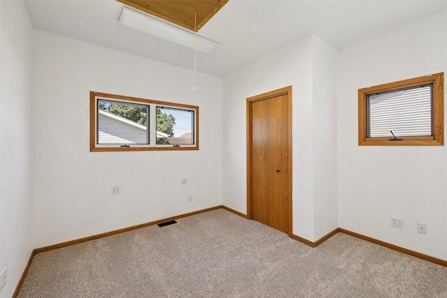 204 N Gaines St, Stuart, IA 50250 - unfurnished bedroom featuring attic access and carpet floors
