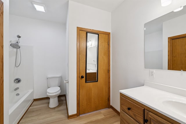 204 N Gaines St, Stuart, IA 50250 - full bath featuring wood finished floors, vanity, and shower / washtub combination