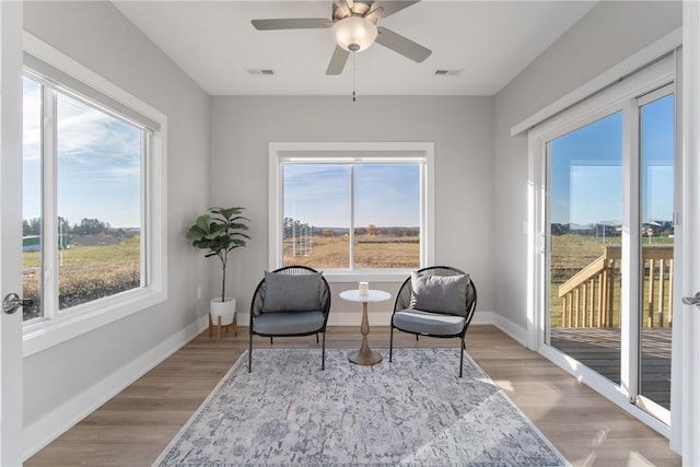 sitting room with light hardwood / wood-style floors and ceiling fan