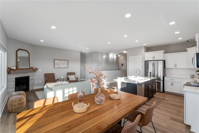 dining space with sink and light hardwood / wood-style floors