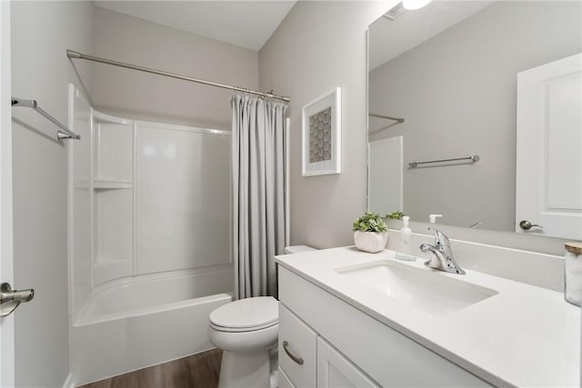 full bathroom featuring hardwood / wood-style floors, shower / tub combo with curtain, oversized vanity, and toilet