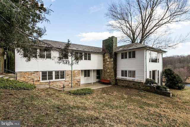 back of property with a yard and a patio