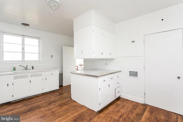 kitchen featuring dark hardwood / wood-style flooring, white cabinetry, and sink