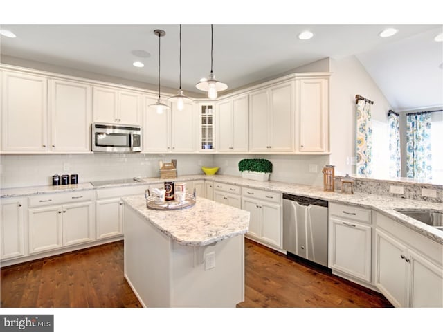 kitchen with lofted ceiling, dark wood-type flooring, a kitchen island, white cabinetry, and stainless steel appliances