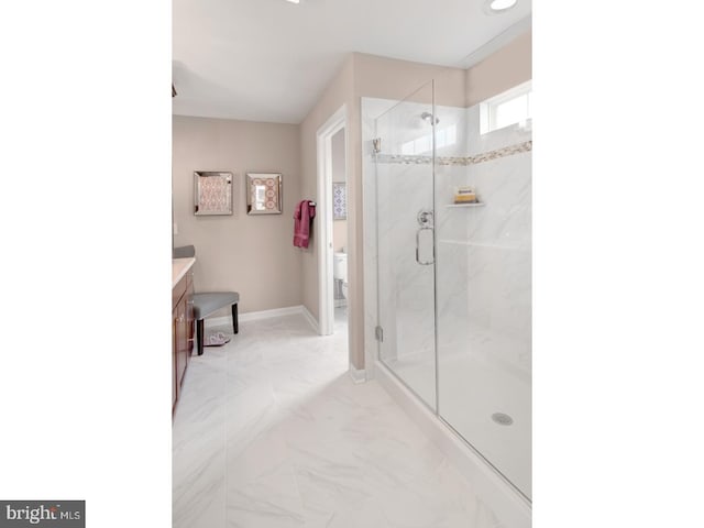 bathroom featuring vanity, toilet, and a shower with door