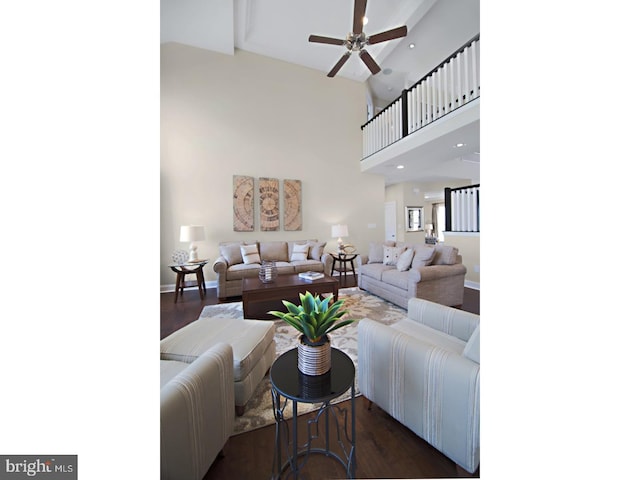 living room featuring a towering ceiling, dark hardwood / wood-style floors, and ceiling fan