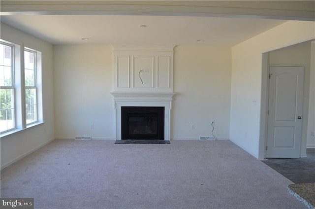 unfurnished living room featuring a fireplace and carpet floors