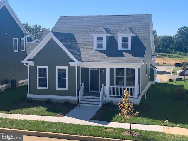 view of front of home featuring a front yard, a porch, and central AC unit