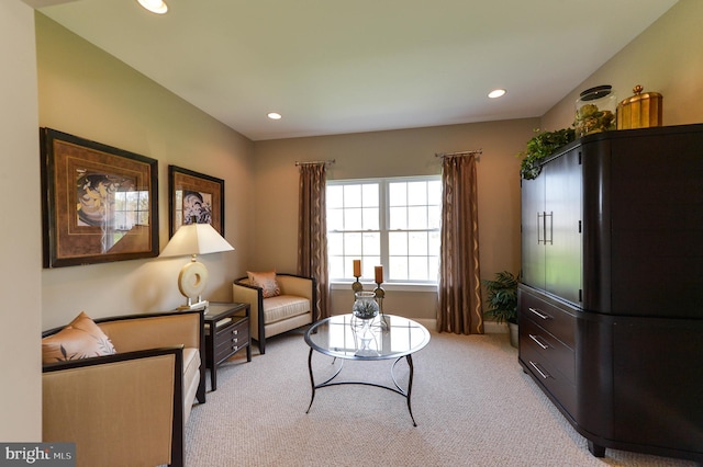 living area featuring light carpet