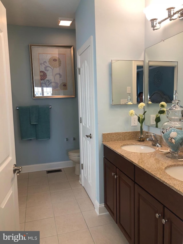 bathroom featuring vanity, tile patterned floors, and toilet