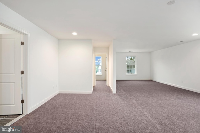 spare room with dark carpet