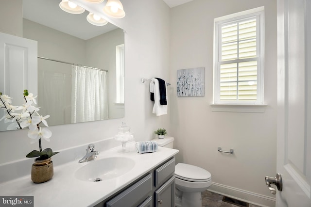 bathroom featuring vanity, curtained shower, and toilet