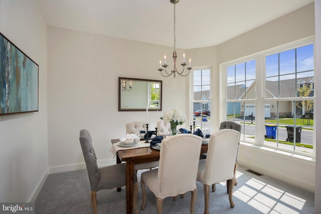 dining room with carpet flooring and a notable chandelier