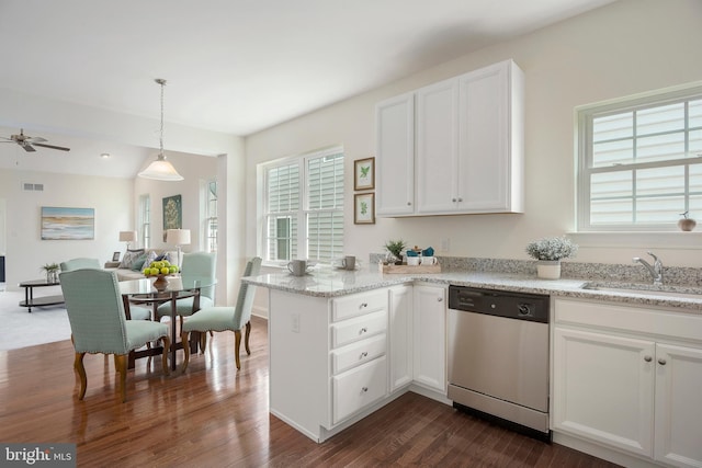 kitchen with sink, dishwasher, hanging light fixtures, white cabinets, and kitchen peninsula