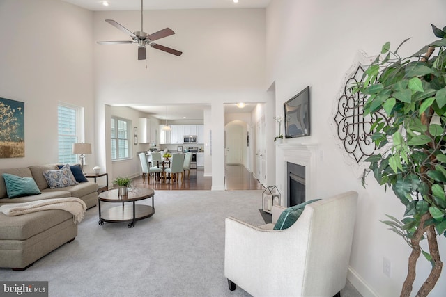 living room featuring a towering ceiling and ceiling fan