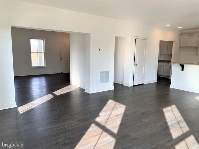 unfurnished living room featuring dark wood-type flooring