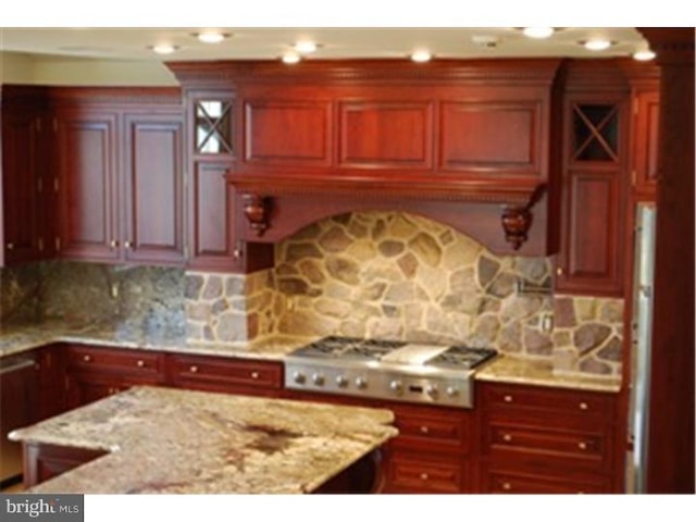 kitchen featuring light stone countertops, tasteful backsplash, and stainless steel gas stovetop