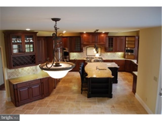 kitchen with tasteful backsplash, a center island, a breakfast bar area, and pendant lighting