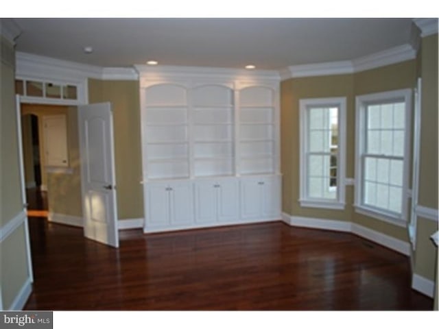 unfurnished room with dark hardwood / wood-style floors and crown molding