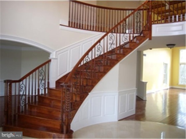 staircase featuring hardwood / wood-style floors and a high ceiling