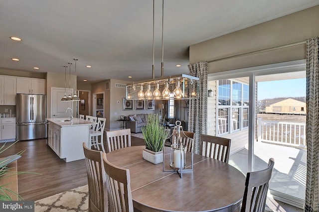 dining space featuring sink and dark wood-type flooring