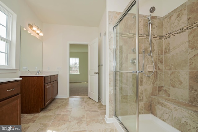 bathroom with a wealth of natural light, vanity, and walk in shower