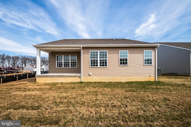 back of property with a yard and central AC