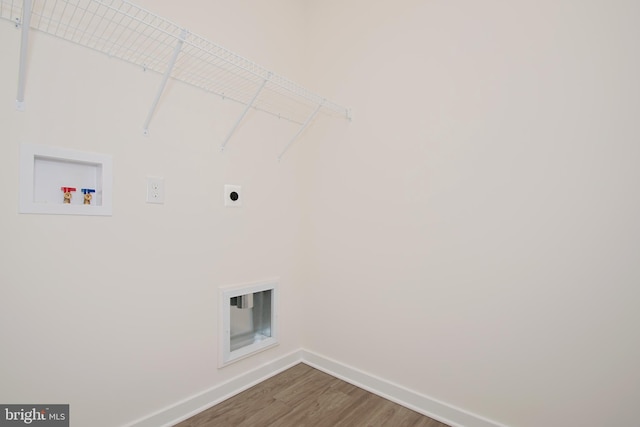 laundry area with hardwood / wood-style flooring, hookup for a washing machine, and hookup for an electric dryer