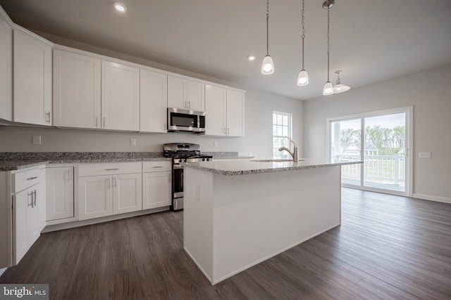 kitchen with white cabinetry, a center island with sink, dark wood-type flooring, and appliances with stainless steel finishes