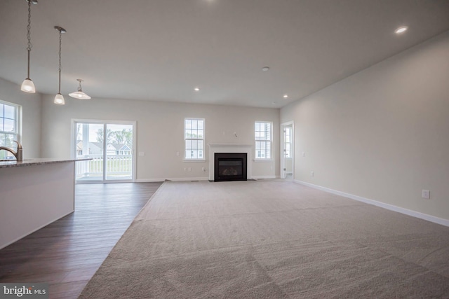 unfurnished living room featuring hardwood / wood-style floors, a healthy amount of sunlight, and sink