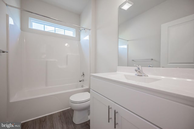 full bathroom with shower / washtub combination, vanity, wood-type flooring, and toilet