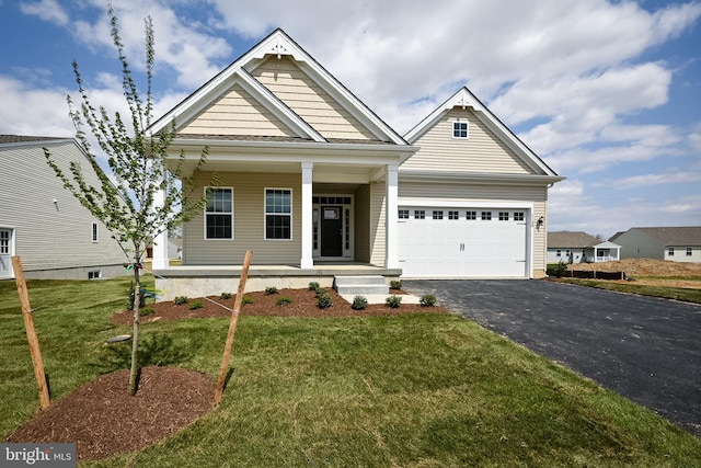 craftsman-style house with covered porch, a garage, and a front yard