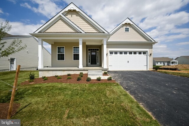 craftsman inspired home featuring a front yard, a garage, and covered porch