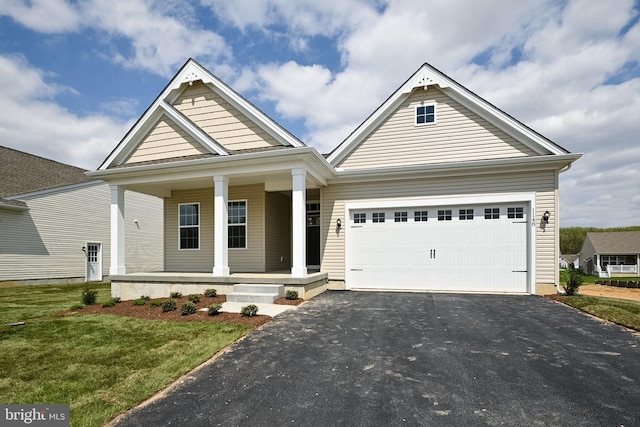 craftsman inspired home with a front yard, a porch, and a garage