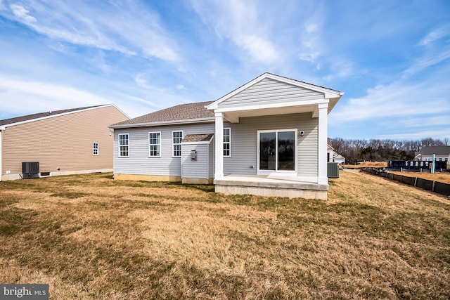 back of property with cooling unit, a patio area, and a yard