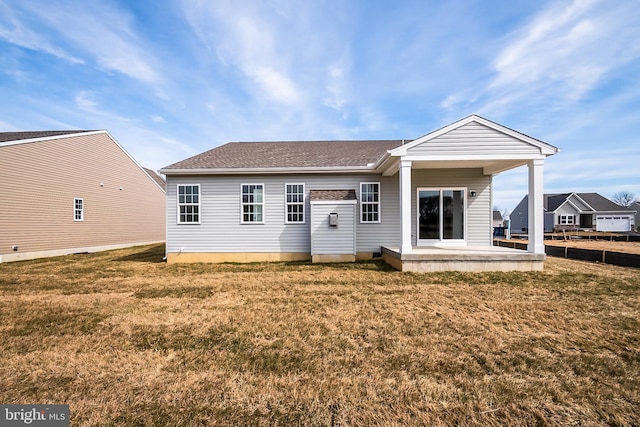 rear view of house featuring a lawn