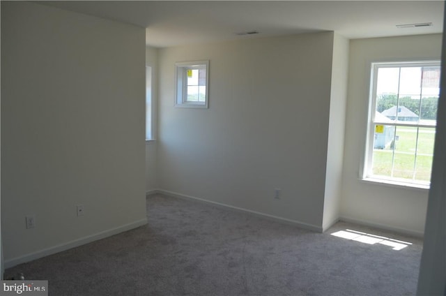 carpeted spare room featuring a wealth of natural light