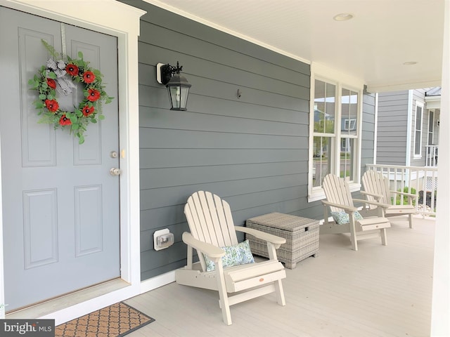 view of exterior entry featuring covered porch