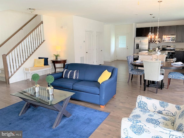 living room with a chandelier and light hardwood / wood-style flooring