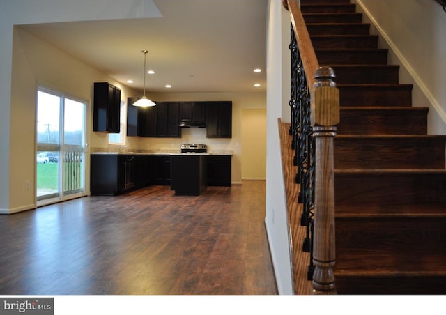 kitchen with stainless steel range oven, hanging light fixtures, and dark wood-type flooring